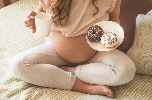 Schwangerschaft und Ernährung. Schwangere genießen Donuts und Tee im Bett, freier Platz. Konzept der Erwartung und Gesundheit — Stockfoto