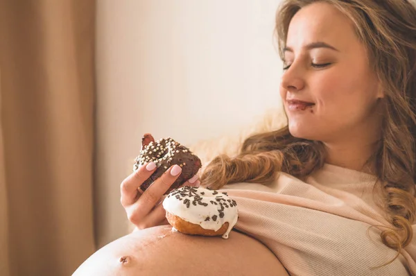 Grossesse et nutrition. Femme enceinte dégustant beignets et thé au lit, espace libre. Concept d'attente et de santé — Photo