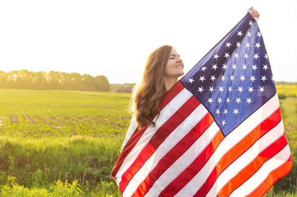 Gelukkige vrouwen rennen in het veld met Amerikaanse vlag USA vieren 4e juli — Stockfoto