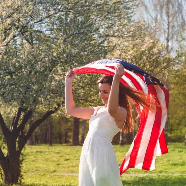 アメリカ国旗を持つ幸せな女性は7月4日を祝う — ストック写真