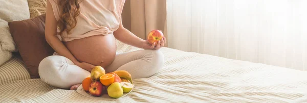 Беременность и здоровое органическое питание. Беременность и грейпфрут. Беременная женщина наслаждается свежими фруктами в постели, свободное место . — стоковое фото