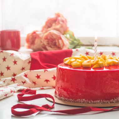 Bir mum ve kırmızı krema ile doğum günü pastası. Ulusal fırın. Mango ile yuvarlak pasta