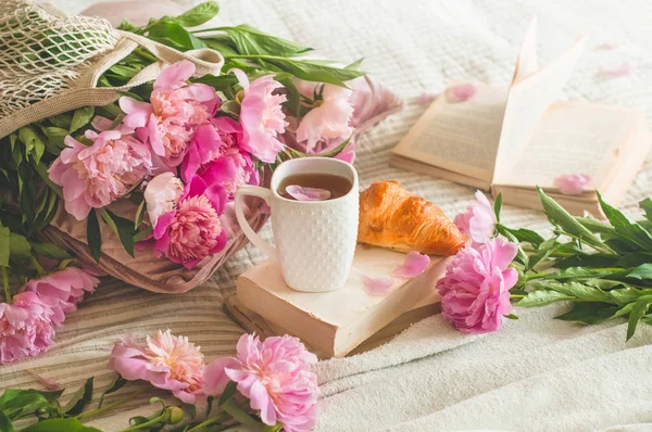 Stillleben Details im Wohnbereich des Wohnzimmers. Tasse Tee mit Taubenblumen und Frühlingsdekor auf den Büchern. — Stockfoto