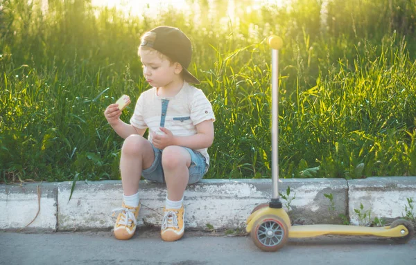 Щаслива Дитина Їсть Їде Скутері Хлопчик Саду Тримає Морозиво Щасливий — стокове фото