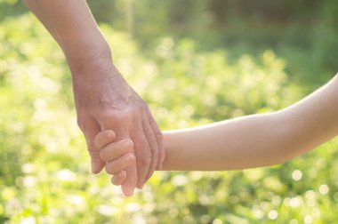 Childs 'ın eli ve yaşlı büyükanne. Çocukları ve yaşlıları koruyan aile kavramı