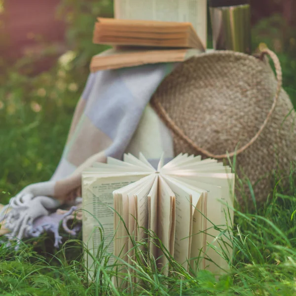 Saco de palha, livro, chapéu e copo térmico em um dia ensolarado de verão — Fotografia de Stock