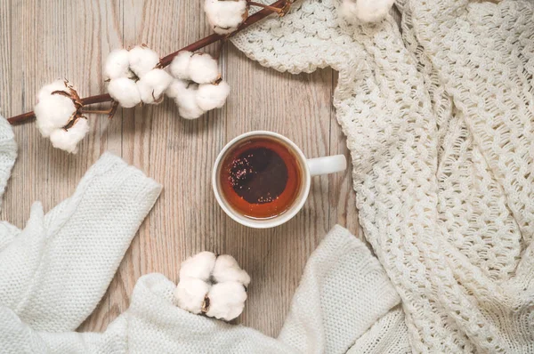 Hintergrund mit warmen Pullovern und Tasse Tee. Kuscheliges Stillleben in warmen Farbtönen, Raum für Text, herbstliches Winterkonzept. — Stockfoto