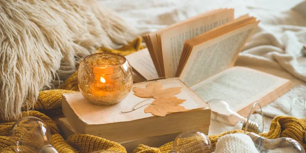 Lar doce. Ainda detalhes da vida em casa interior da sala de estar. Camisolas e vela, decoração de outono nos livros . — Fotografia de Stock