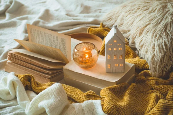 Sweet Home. Still life details in home interior of living room. Sweaters and candle,  autumn decor on the books. — Stock Photo, Image