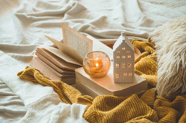 Sweet Home. Still life details in home interior of living room. Sweaters and candle,  autumn decor on the books. — Stock Photo, Image