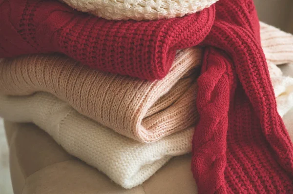 Una pila de suéteres de punto en el interior de la sala de estar — Foto de Stock