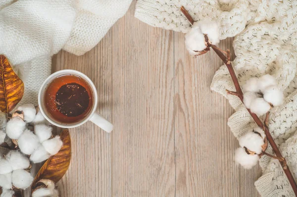 Hintergrund mit warmen Pullovern und Tasse Tee. Kuscheliges Stillleben in warmen Farbtönen, Raum für Text — Stockfoto