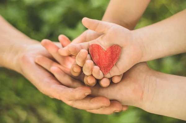 Childs hand en oude hand grootmoeder houden hart. Concept idee van liefde familie bescherming kinderen en ouderen mensen grootmoeder — Stockfoto