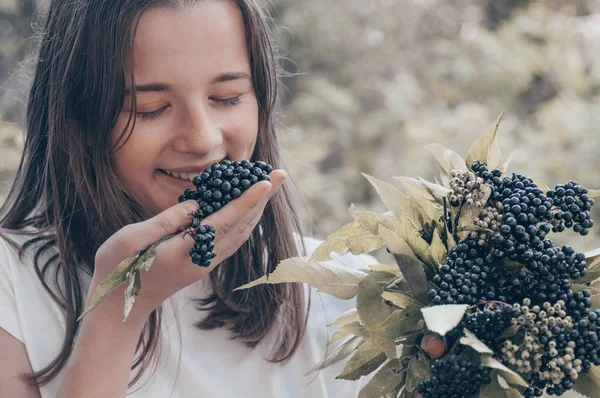 Flicka innehar i händerna kluster frukt Svart fläder i trädgården (Sambucus nigra). Äldste, Black Elder. — Stockfoto