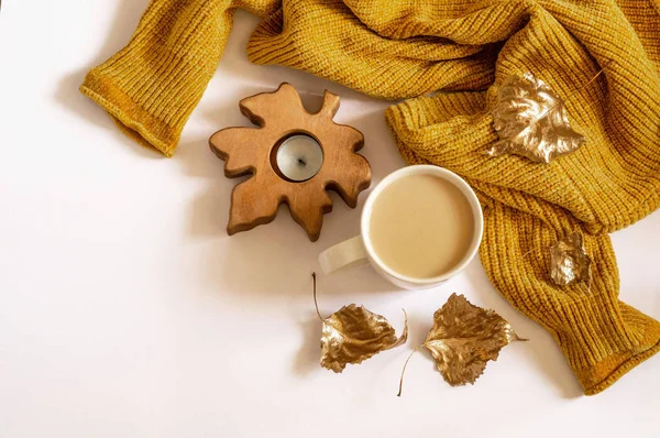 Autumn Winter  composition. Background with warm sweaters and cup tea. Cozy still life in warm shades, space for text