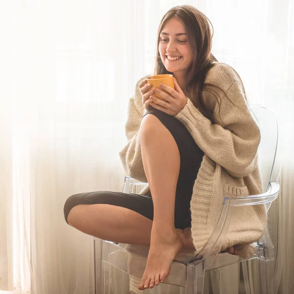 Vrouw met kopje warme drank bij het raam. Kijkend naar het raam en Drink thee. Goedemorgen met thee. — Stockfoto