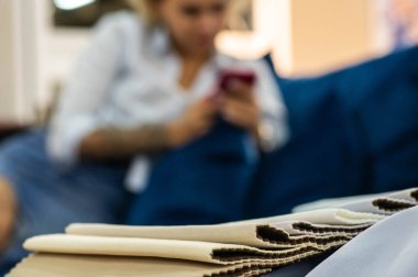 Genç bir kadın doku örneklerine bakar. Kanepenin rengini seçer. 