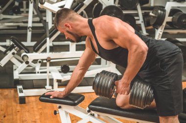 Spor salonunda beden eğitimi hocası. Kas formundaki ve ince vücutlu erkek model.