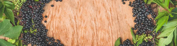 Ahşap bir arka planda meyve siyah mürver (Sambucus nigra). Yaşlı, siyah yaşlı.