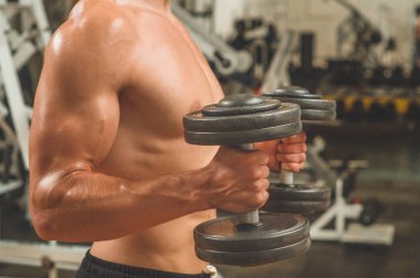 Spor salonunda beden eğitimi hocası. Kas formundaki ve ince vücutlu erkek model.