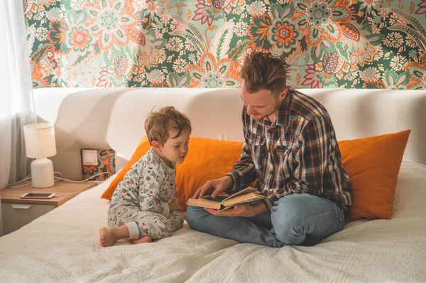Apa és fia együtt olvastak egy könyvet, mosolyogtak és ölelkeztek. Boldog apák napját!. — Stock Fotó