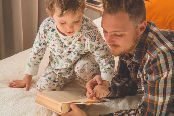 พ่อกับลูกอ่านหนังสือด้วยกัน ยิ้มและกอดกัน สุขสันต์วันพ่อ . — ภาพถ่ายสต็อก
