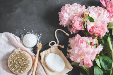 Siyah arka planda pembe şakayık çiçekli doğal organik kozmetik ürünler.. 