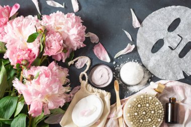 Siyah arka planda pembe şakayık çiçekli doğal organik kozmetik ürünler.. 