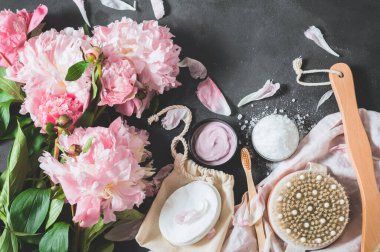 Siyah arka planda pembe şakayık çiçekli doğal organik kozmetik ürünler.. 