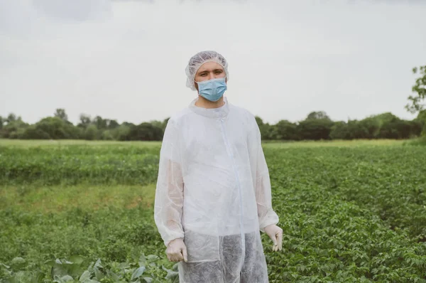 Man in protective suit, medical mask and rubber gloves for protect from bacteria and virus