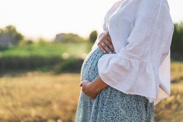 Happy Attractive pregnant woman in outdoors. Concepts of pregnancy and family