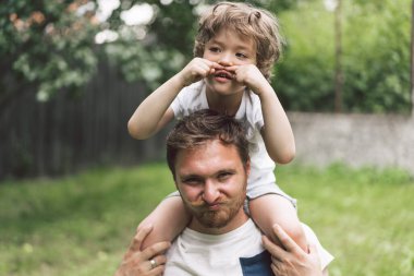 Baba ve oğlu dışarıda oynayıp sarılıyorlar. Babalar Günü kavramı. 
