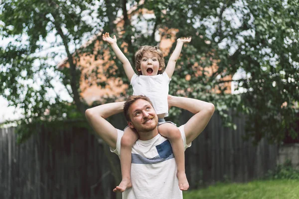 Vater und Sohn spielen und umarmen sich im Freien. Vatertagskonzept. — Stockfoto