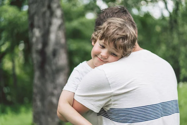 Vader en zijn zoon spelen en knuffelen buiten. Begrip vaderdag. — Stockfoto