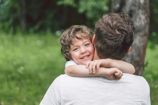 พ่อและลูกชายของเขาเล่นและกอดกันข้างนอก คอนเซปต์ของวันพ่อ . — ภาพถ่ายสต็อก