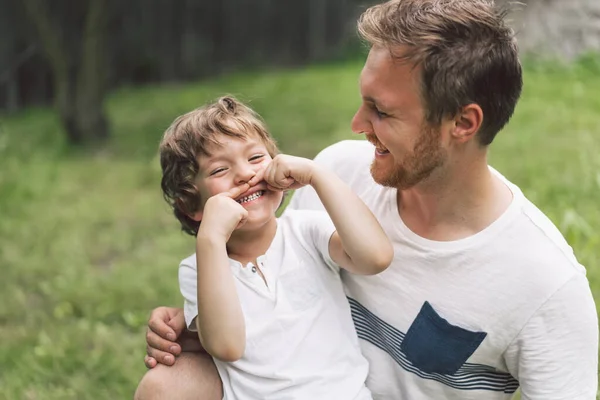 Pai e seu filho brincando e abraçando ao ar livre. Conceito do dia do Pai . — Fotografia de Stock