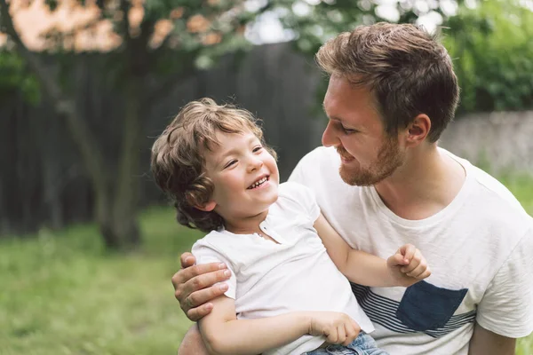 Pai e seu filho brincando e abraçando ao ar livre. Conceito do dia do Pai . — Fotografia de Stock