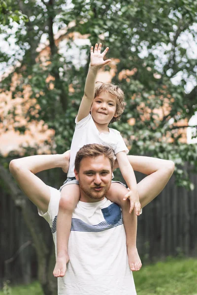 Vater und Sohn spielen und umarmen sich im Freien. Vatertagskonzept. — Stockfoto