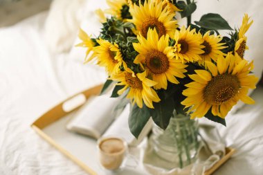 Oturma odasının içinde hala hayat var. Ayçiçekleri, kahve ve açık bir kitap. Oku, Dinlen