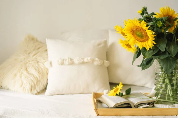 Oturma odasının içinde hala hayat var. Ayçiçekleri, kahve ve açık bir kitap. Oku, Dinlen