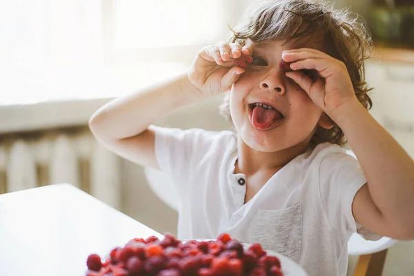 Anak kecil yang cantik makan raspberry segar. Makanan sehat, anak-anak dan pembangunan. — Stok Foto