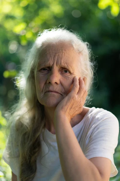 Retrato de uma avó adulta de cabelos grisalhos contra o fundo da natureza — Fotografia de Stock