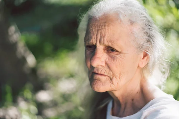 Retrato de uma avó adulta de cabelos grisalhos contra o fundo da natureza — Fotografia de Stock