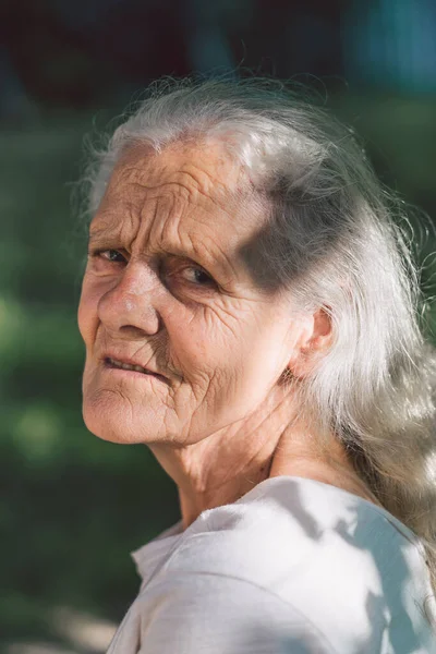 Retrato de uma avó adulta de cabelos grisalhos contra o fundo da natureza — Fotografia de Stock