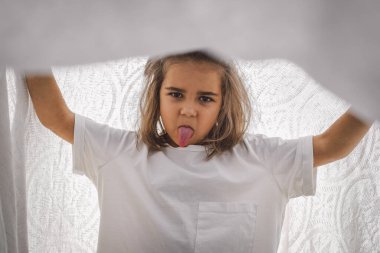 Mutlu çocuk. Battaniyeyle oynayan komik kız. Gülümseyen kız çocuğu. Doğadaki neşeli çocuk.