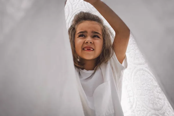 Gelukkig kind. Grappig meisje dat met een deken speelt. Een lachend meisje. Vrolijk kind buiten in de natuur — Stockfoto