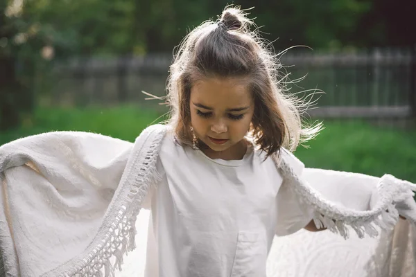 Criança feliz. Menina engraçada brincando com um cobertor. Miúda sorridente. Criança alegre ao ar livre na natureza — Fotografia de Stock