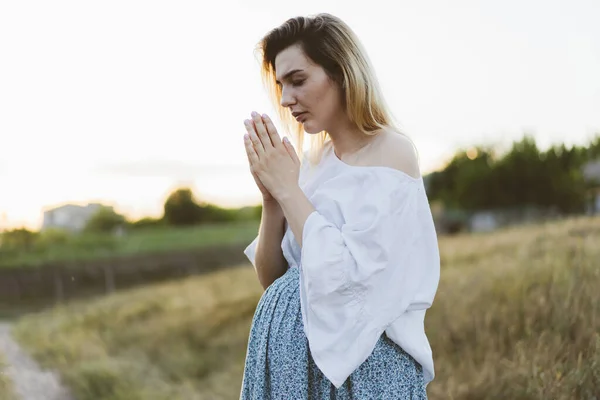 Pregnant woman praying outdoors on at sunset. Concept for faith, spirituality and religion. — Stock Photo, Image