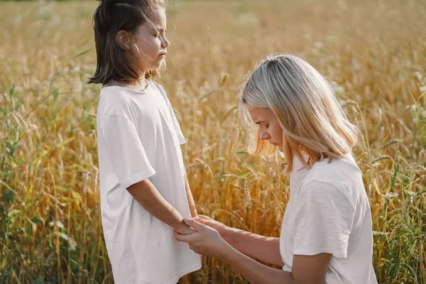 Gadis berdoa dan berpegangan tangan di ladang gandum. Berdoalah bagi Allah satu sama lain saling mendukung — Stok Foto