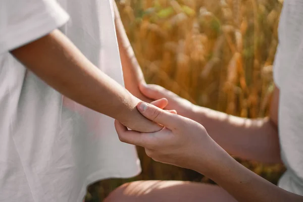 Niñas rezando y cogidas de la mano en un campo de trigo. Rezad juntos por Dios. — Foto de Stock